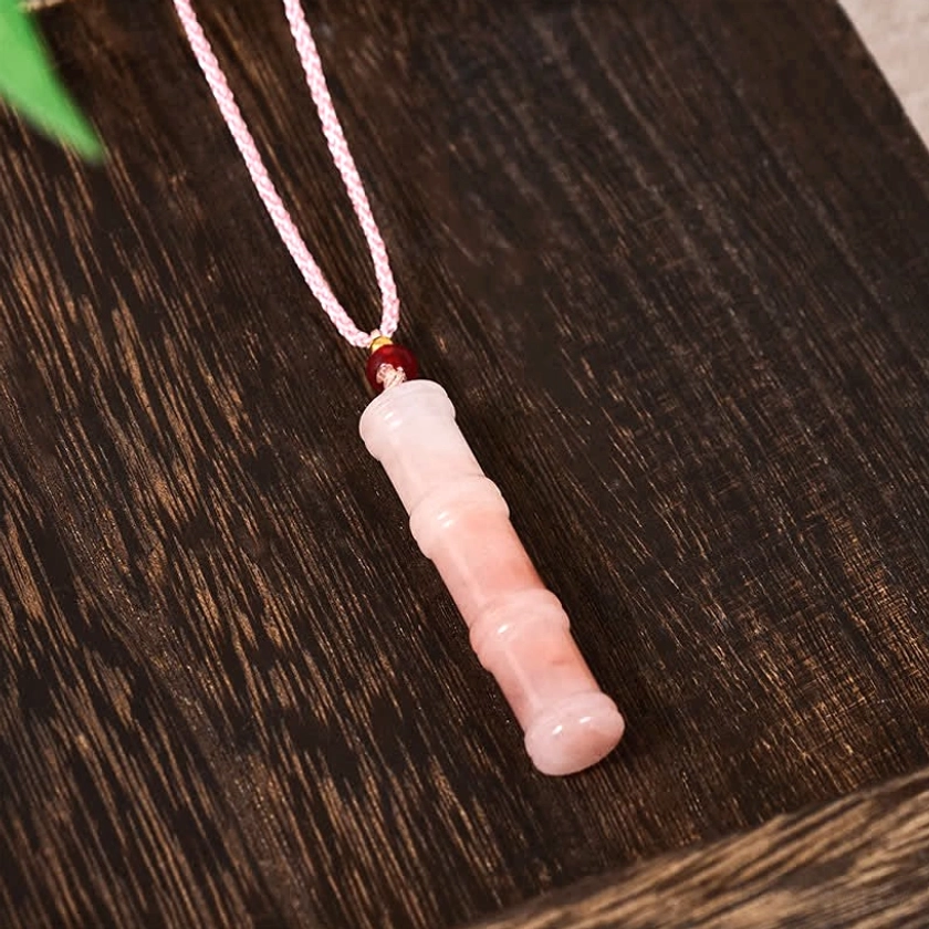 Pink braided necklace cord with quartzite jade bamboo pendant on dark wood background, displaying warm mineral patterns and natural stone coloration
