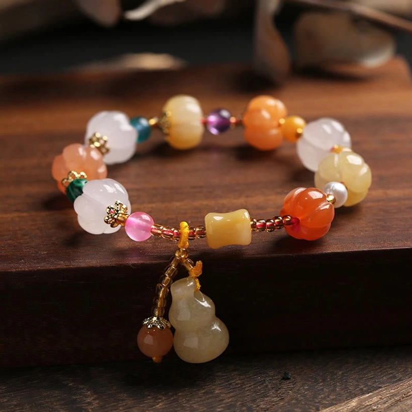 Golden silk jade wealth charm bracelet with hanging gourd pendant and gold metal accents