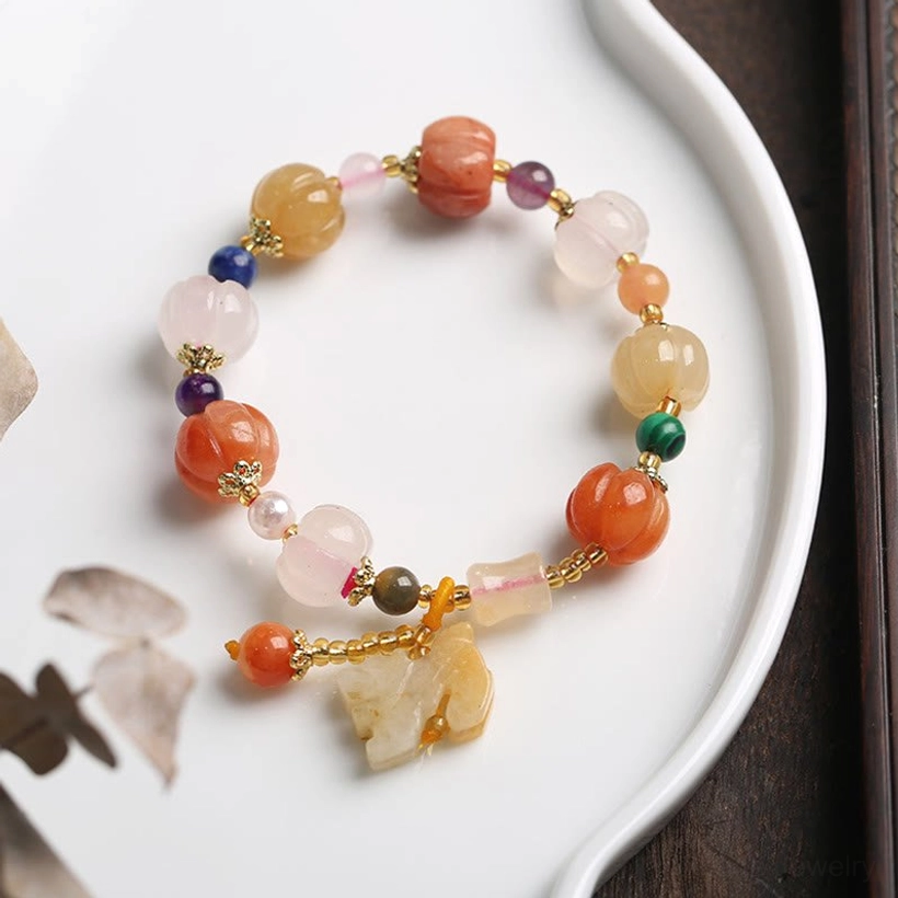 Close-up hand wearing jade bracelet with hanging gourd pendant mixed colorful stone beads