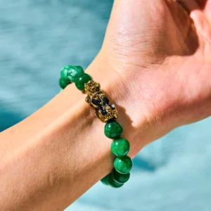Green jade Pixiu bracelet worn on wrist with water background showing side profile detail