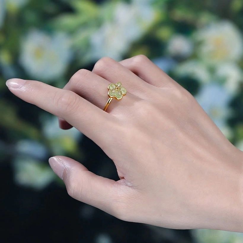 Plum Blossom Jade Copper Ring - Side view worn on index finger showing elegant dainty styling against natural background