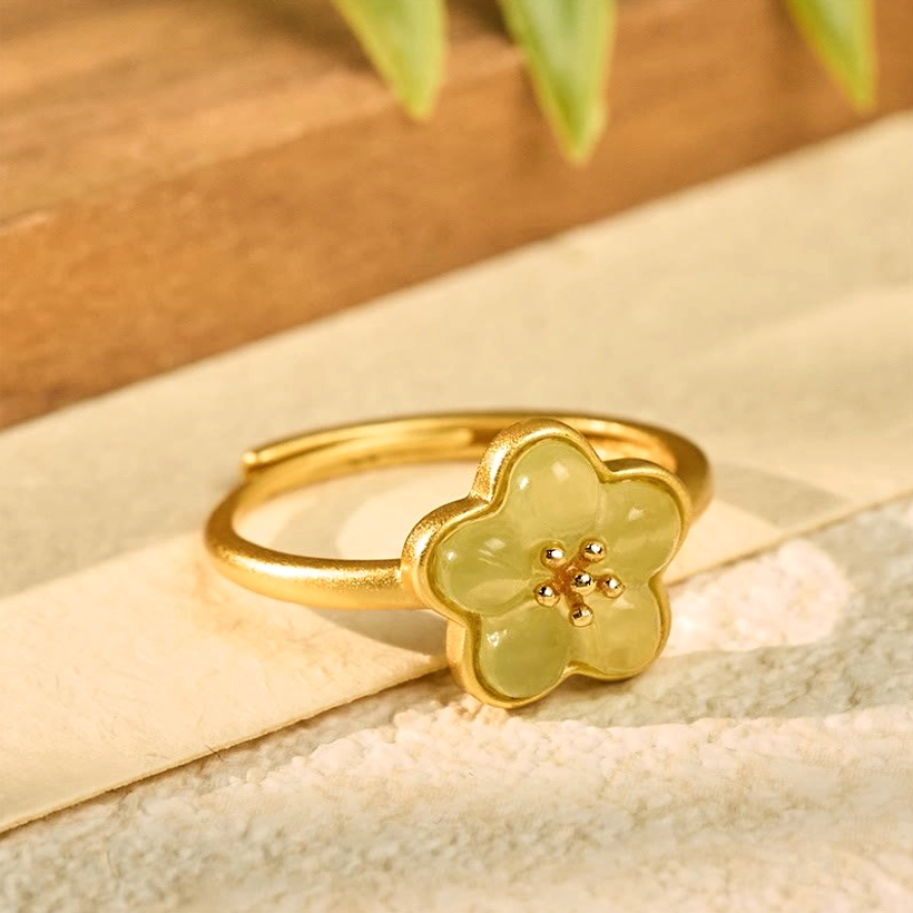 Hetian Jade Plum Blossom Ring - Top oblique view displaying intricate carved flower design with copper band and bead accents