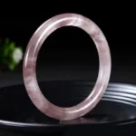 Single lavender purple jade bangle bracelet polished smooth on black ceramic plate