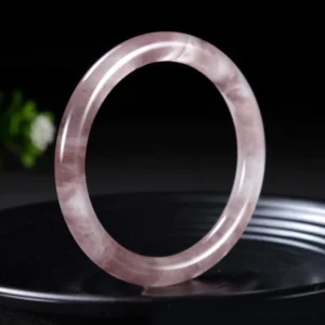 Single lavender purple jade bangle bracelet polished smooth on black ceramic plate