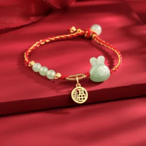 Year of the rabbit jade bracelet with adjustable red cord and golden fu charm detail shot