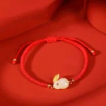 Year of Rabbit white jade rabbit charm bracelet with 925 sterling silver accent on red fabric, featuring adjustable red string and protective jade talisman