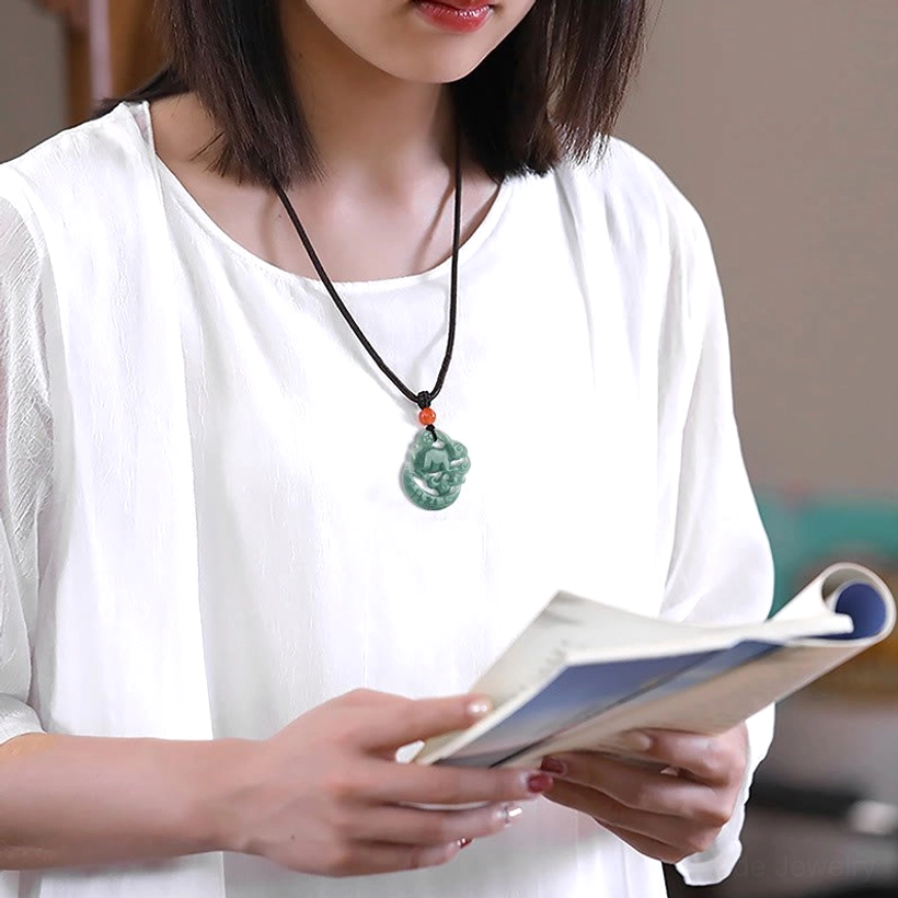 Year of the Rabbit jade necklace worn at collarbone, casual indoor lifestyle wear, black cord elegant styling