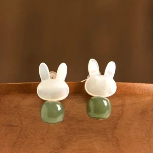 Side profile view of cute rabbit charm jade earrings showing glossy smooth finish and metal ear posts