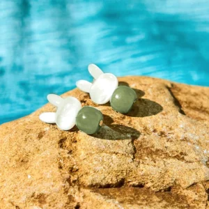 Cute rabbit Hetian jade tridacna stone stud earrings with white shell rabbit charms and dark green jade beads on stone background