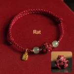 Rat zodiac Hetian jade cinnabar lucky bracelet with red cord and fu character pendant on burgundy velvet background