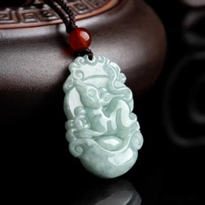 Rat Chinese zodiac jade pendant with carving details on wooden surface angled view