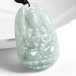 Rat Zodiac Natal Buddha jade pendant carved with intricate Buddhist details, light cyan jade with black cord on white background
