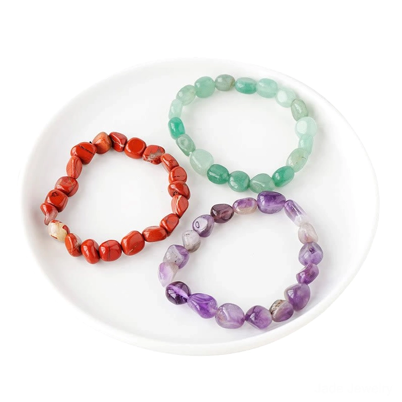 Red stone and purple amethyst irregular crystal beaded bracelets on white ceramic plate