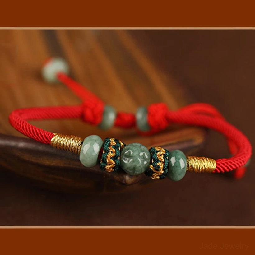 Red jade bracelet full product view with gold twisted accents on wooden background