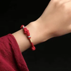 Red string jade lucky knot bracelet worn on wrist showing adjustable fit and comfort