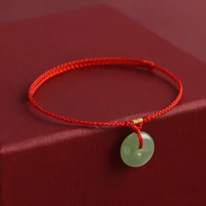 Red rope jade peace buckle bracelet three-quarter angle view showing braided cord detail
