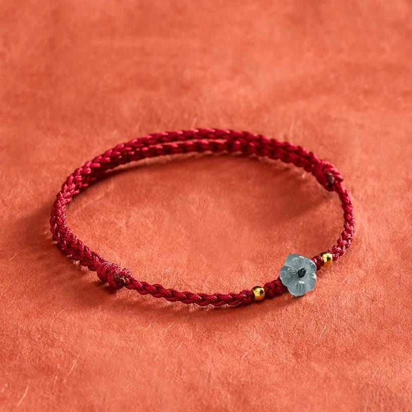 Red string blessing bracelet side profile showing full loop with adjustable knot details and jade charm with gold accents