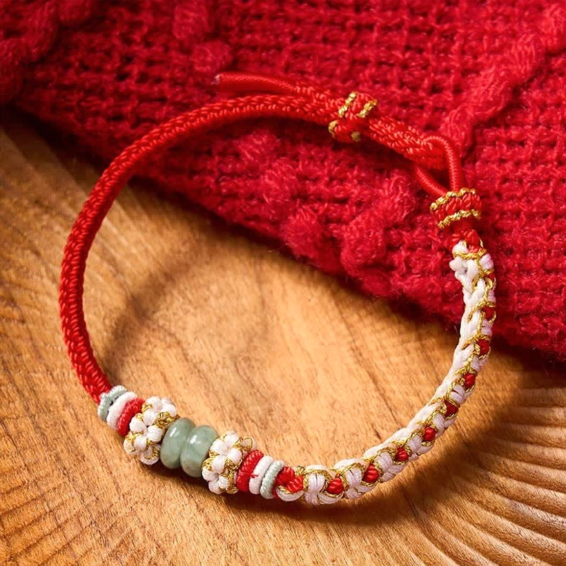Red string jade luck bracelet with adjustable braided knot flower accent low angle