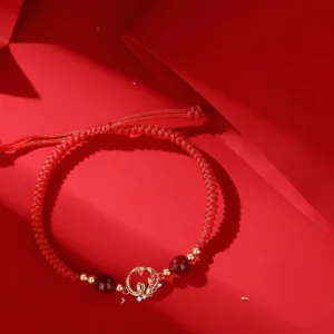 Adjustable red braided jade bracelet with metal snake and koi charm and sliding knot closure