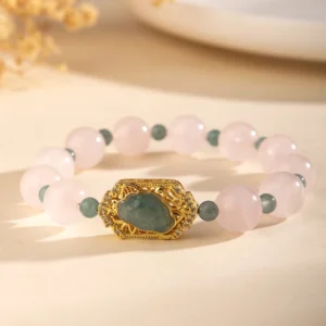 Rose quartz and jade Pixiu bracelet side angle showing pink beads, green jade spacers, and ornate gold charm