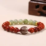 Rosewood cyan jade lotus bodhi bracelet overhead shot with gold spacer beads on wooden surface