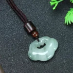 Ruyi jade lock charm necklace with small Tianshan jade pendant and brown woven cord, front close-up view