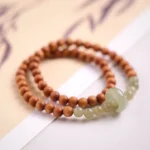 Sandalwood Hetian jade double wrap bracelet flat lay showing brown sandalwood beads with light green jade ring accents