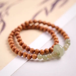 Sandalwood Hetian jade double wrap bracelet flat lay showing brown sandalwood beads with light green jade ring accents