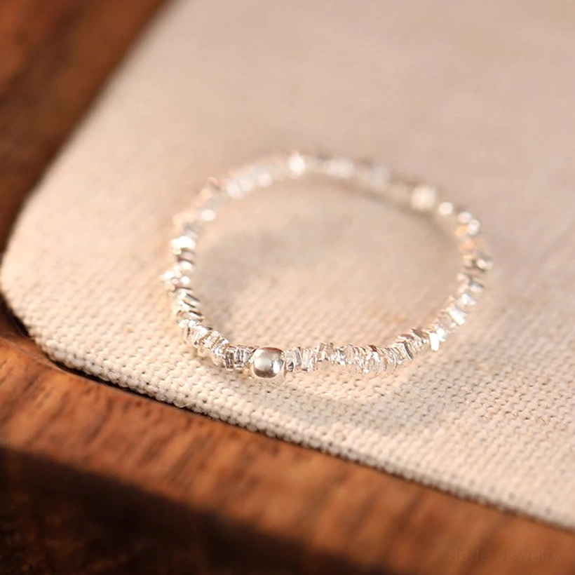 Close-up of minimalist silver elastic stretch ring with polished 925 sterling silver chips