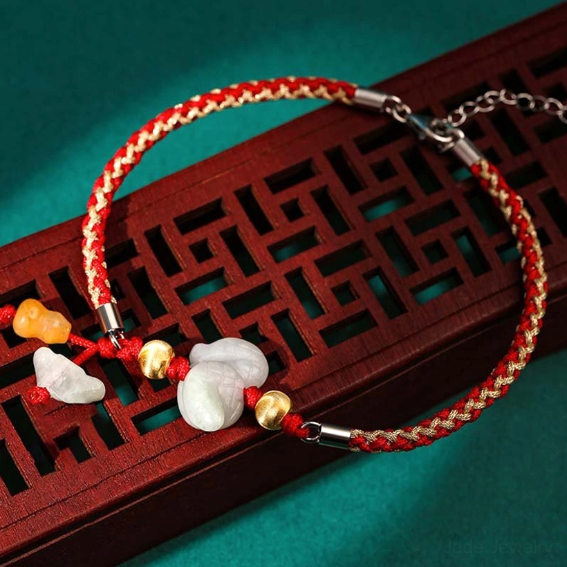 Snake zodiac jade bracelet with red string and protective energy talisman on traditional background