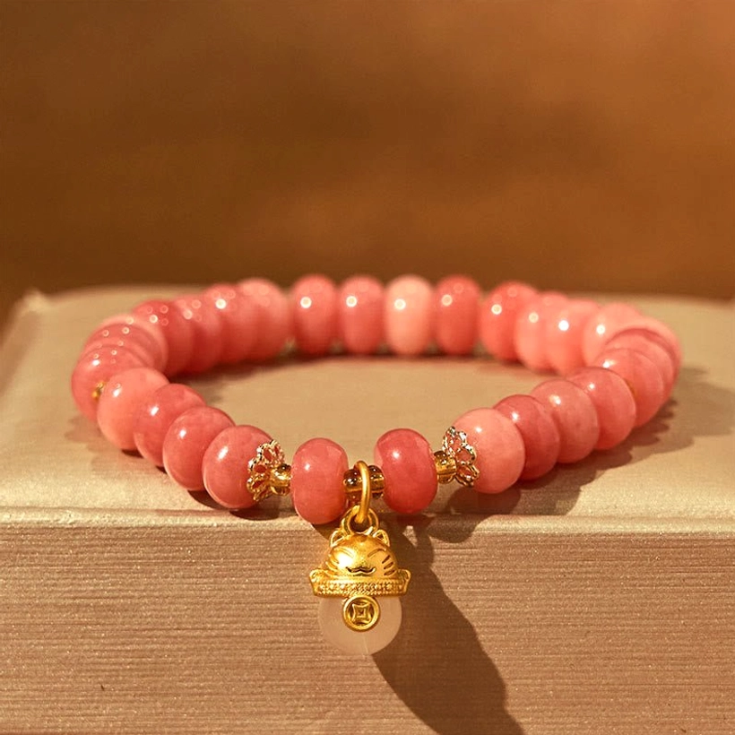Pink Strawberry Quartz Healing Bracelet with Gold Lucky Cat and Spacer Beads - Flat Lay on Beige Box