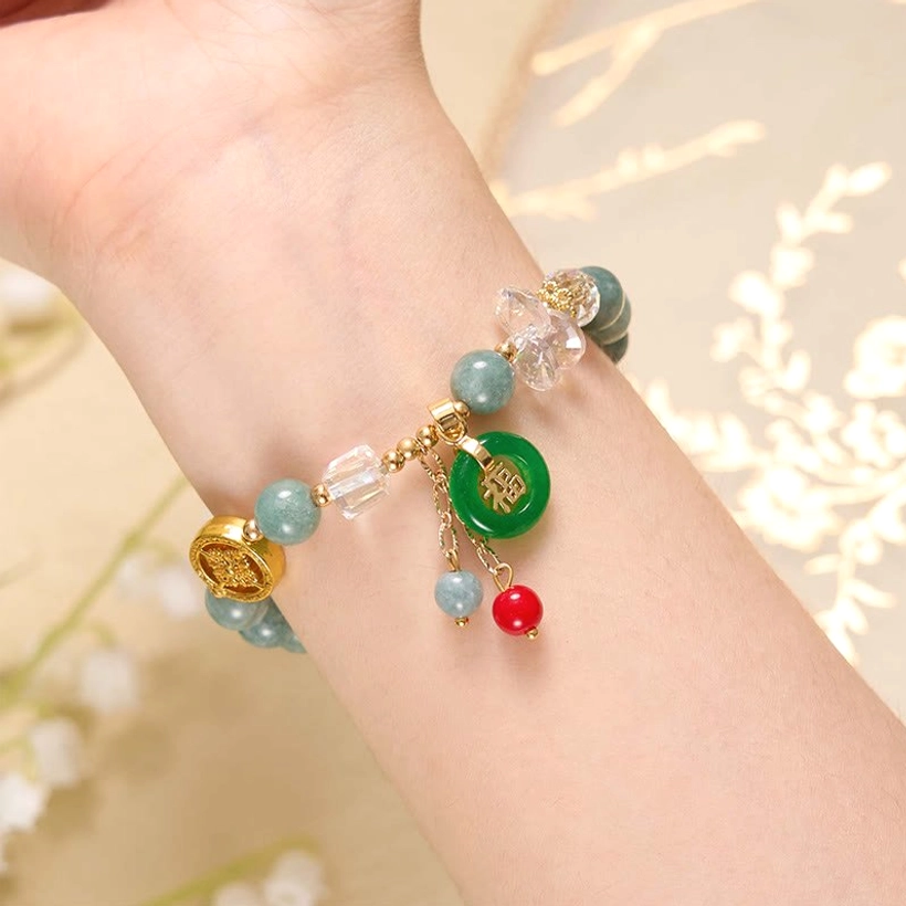 Handcrafted strawberry quartz Fu charm bracelet detail showing craftsmanship and natural stone variations