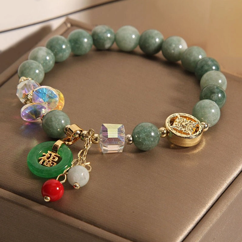 Strawberry quartz jade bracelet with Fu charm pendant displayed on neutral background full view