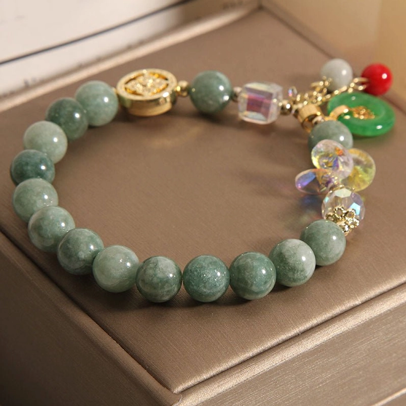 Pink strawberry quartz beaded bracelet with jade and gold Fu charm tassel pendant detail