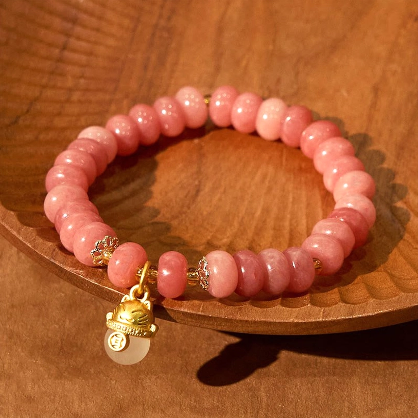 Strawberry Quartz Jade Bracelet with Lucky Cat Charm and Sparkly Gold Details - Wooden Bowl Flat Lay