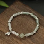 Tianshan jade bamboo sterling silver bracelet overhead view on wooden desktop with natural lighting