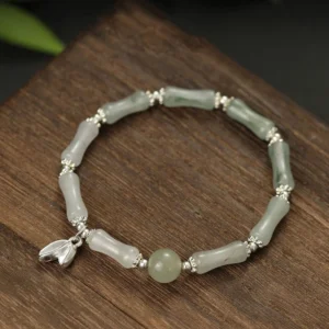 Tianshan jade bamboo sterling silver bracelet overhead view on wooden desktop with natural lighting