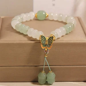 Tianshan jade butterfly prosperity bracelet with abacus beads and double jade tassel, displayed on brown jewelry box