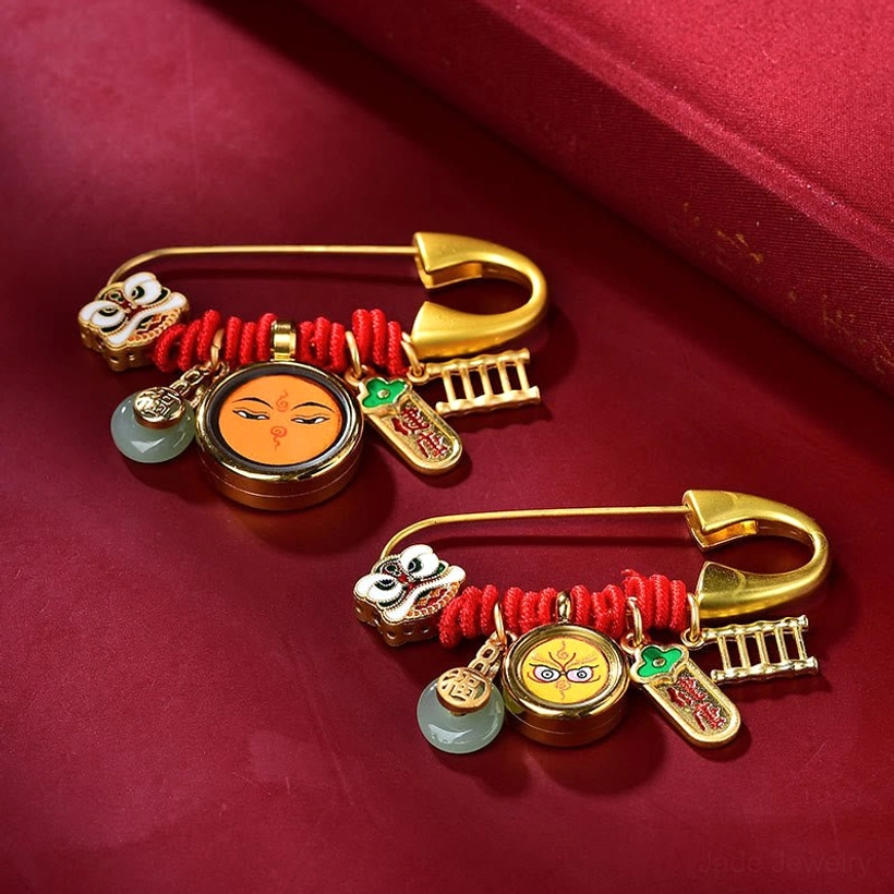 Tibetan dancing lion jade peace brooch with copper hardware and red cord on red satin background