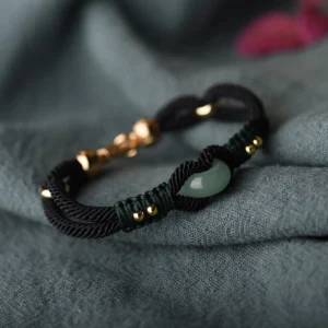 Tibetan jade couple bracelet with heart-shaped jade charm, black woven rope, and gold-toned metal accents - side view