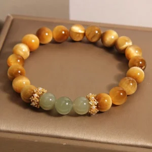 Close-up detail of tiger eye jade bracelet showing gold rhinestone pearl spacers and mixed stone bead layout arrangement