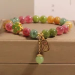 Multicolor tourmaline jade four-leaf clover bracelet with gold Ruyi charm displayed on premium jewelry box