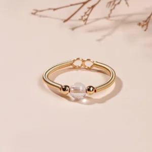 White crystal quartz bead adjustable open ring on gold alloy spring band, clear stone clarity ring top down view