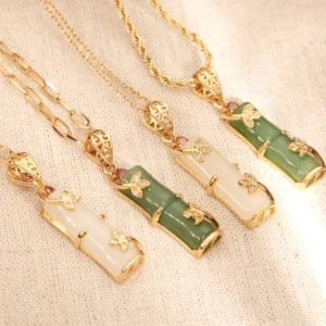 White and cyan bamboo jade necklace flat lay - dual-color jade pendant with gold hardware and decorative accents