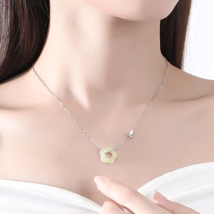 Woman wearing white gold sterling silver Hetian jade butterfly necklace close-up on neck and collarbone