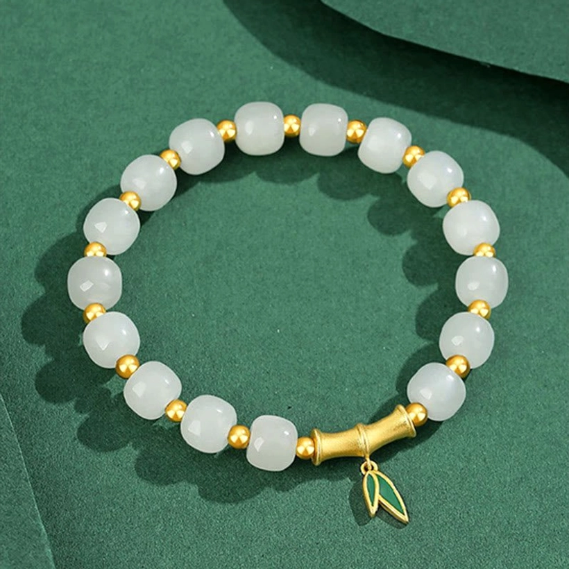 Hetian white jade bamboo bracelet flat lay showing evenly spaced beads with central bamboo charm accent