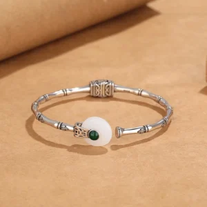 Open-ended jade bangle bracelet overhead flat lay displaying full bamboo joint design and carved decorative elements