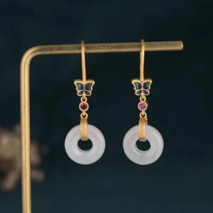 Feng shui white jade butterfly earrings hanging display showing matte gold hardware and enamel butterfly design