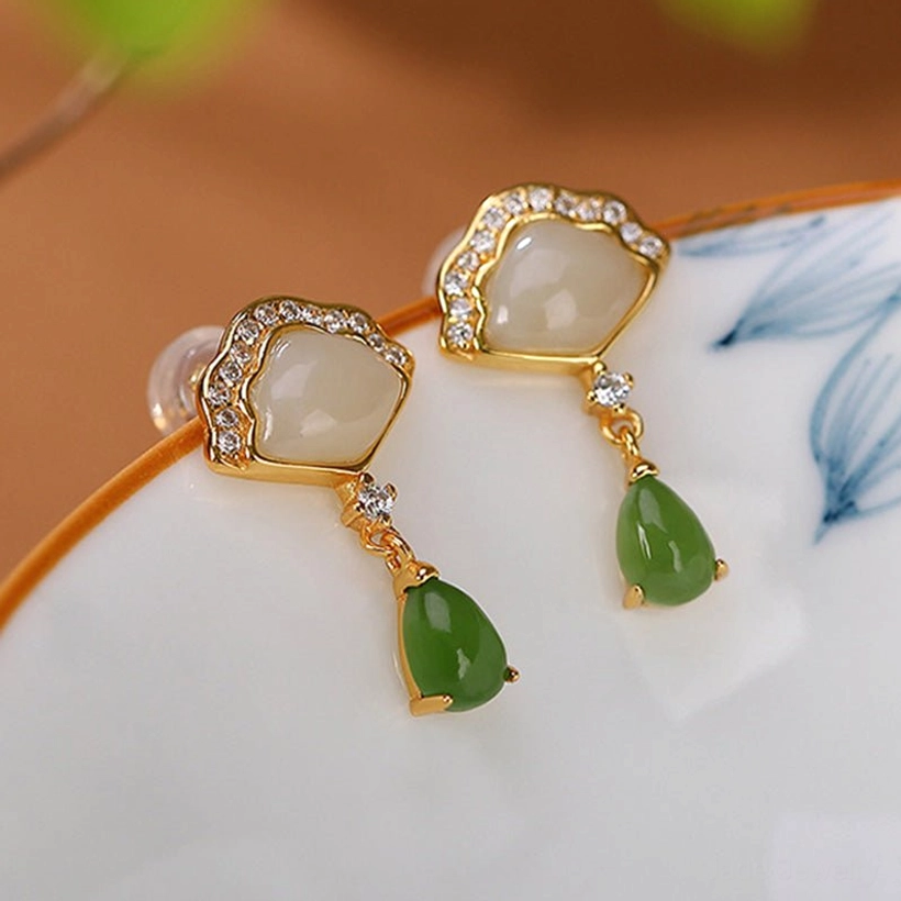 Gold plated jade earrings on blue porcelain with teardrop pendant detail