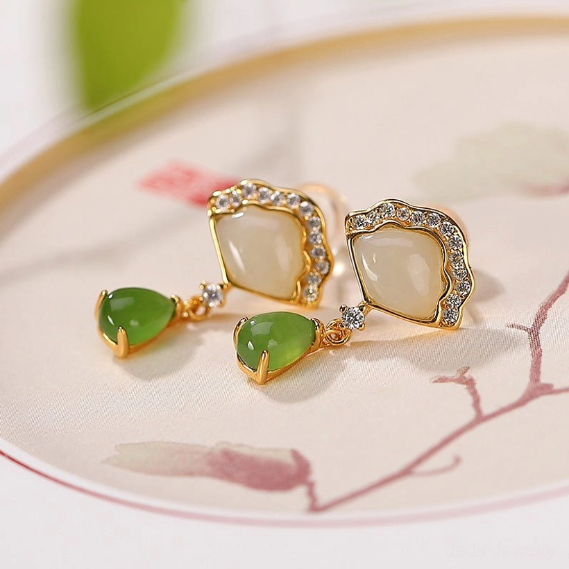 Jade fan drop earrings flat lay on Chinese ceramic plate with gold rhinestone detail